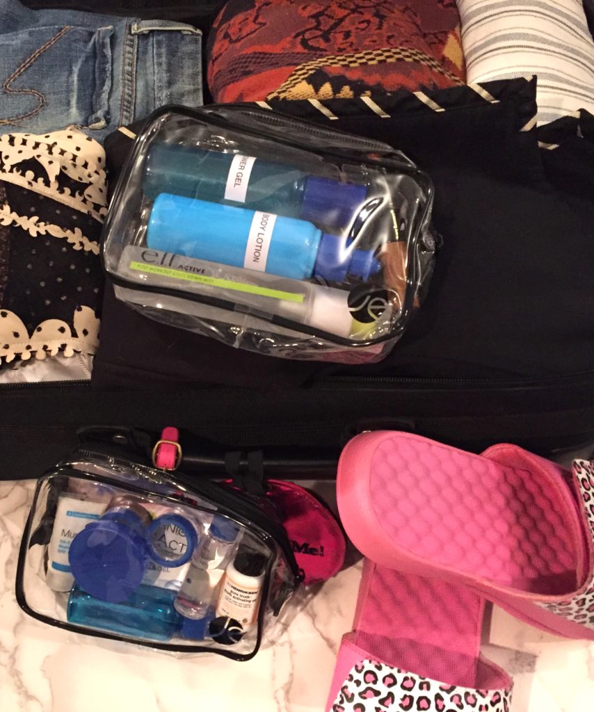 Carry-on bag packed with beauty products and clothes 